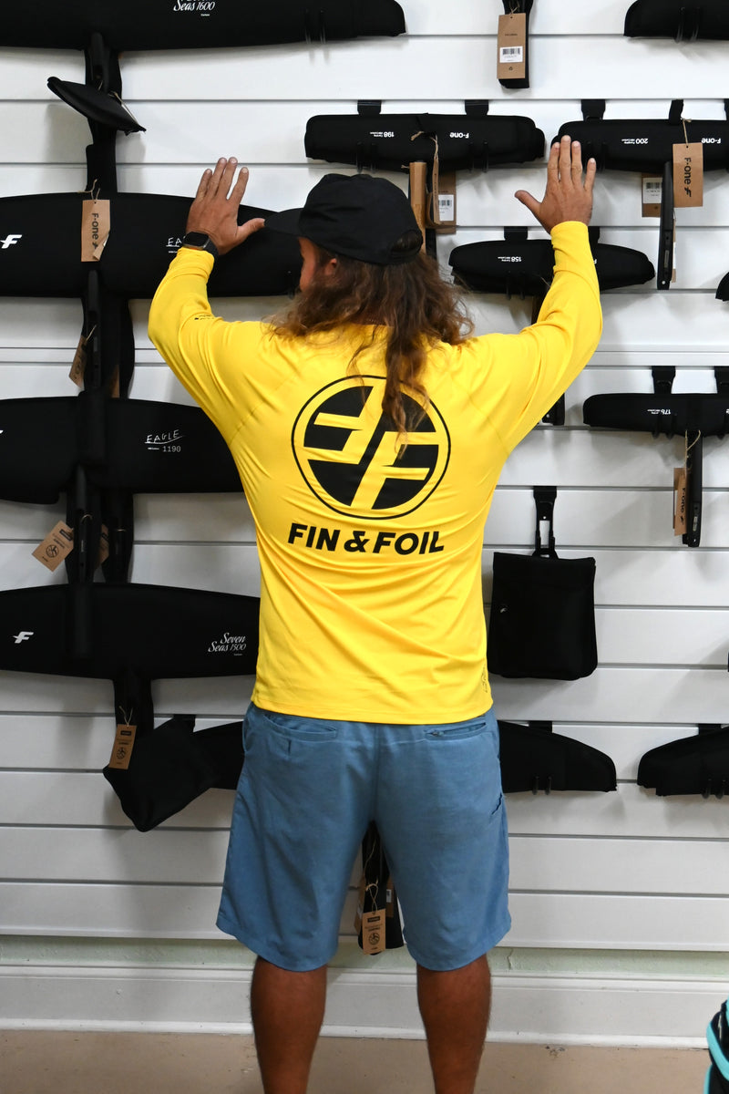Yellow Xcel VentX long-sleeve rash guard,back view. Hydrofoil display background